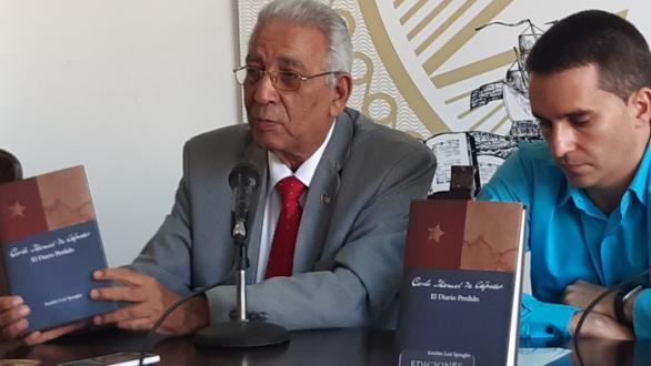 Eduardo Torres Cuevas sostiene libro y a su lado Mario Cremata Ferrán