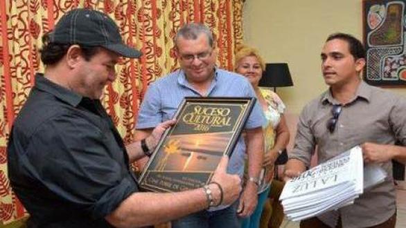 El actor Jorge Perugorría (I), Presidente del Comité Organizador del Festival Internacional de Cine de Gibara, recibe el certificado de Suceso Cultural, otorgado por la crítica especializada, durante la conferencia de prensa efectuada en el salón del protocolo del teatro Eddy Suñol, de la ciudad de Holguín. Foto: ACN/ Juan Pablo CARRERAS