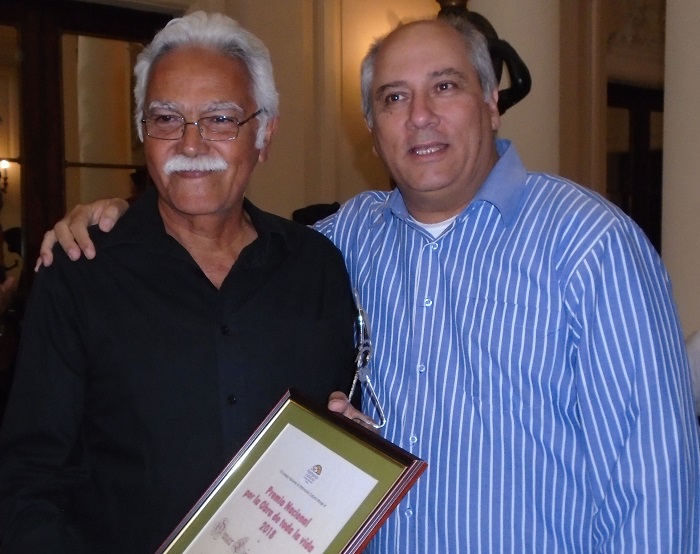 Omar López recibe el premio de manos de Alpidio Alonso