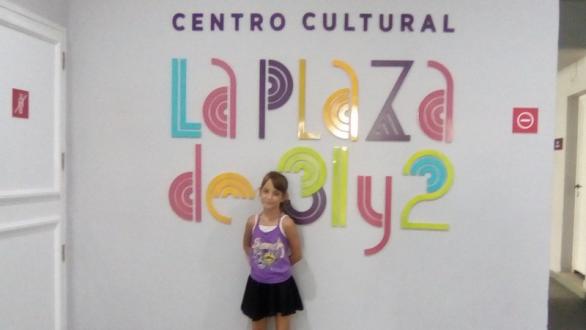 niña junto al cartel de la entrada 