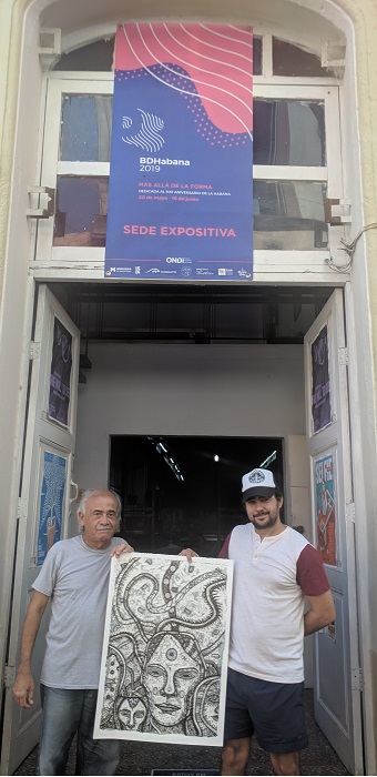 López Oliva and the printer-artist Carlos Almeida, with one of the prints in hands, at the door of the Portocarrero Workshop