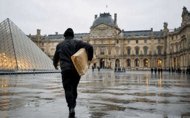 Persona alejándose del Museo del Louvre con una obra envuelta bajo el brazo en una imagen conceptual sobre los robos de arte más famosos de la historia