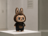 Labubu expuesta sobre un pedestal en una galería de arte contemporáne