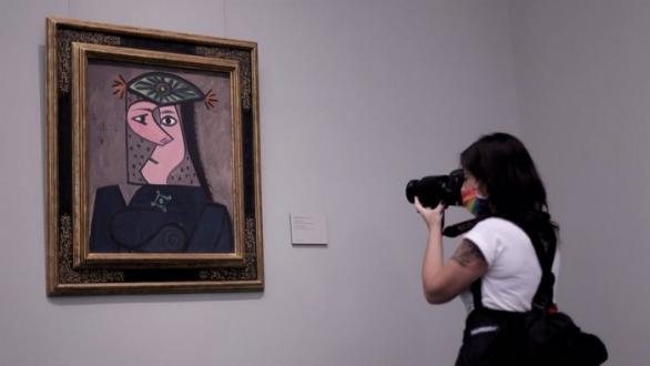Mujer toma foto a obra de arte. Foto: estoeshoy