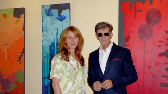 dos personas con obras de arte al fondo