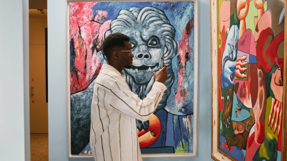 Un visitante utiliza su teléfono móvil ante varias pinturas, una imagen que refleja cómo la fotografía está transformando nuestra forma de mirar, disfrutar y recordar el arte en los museos.