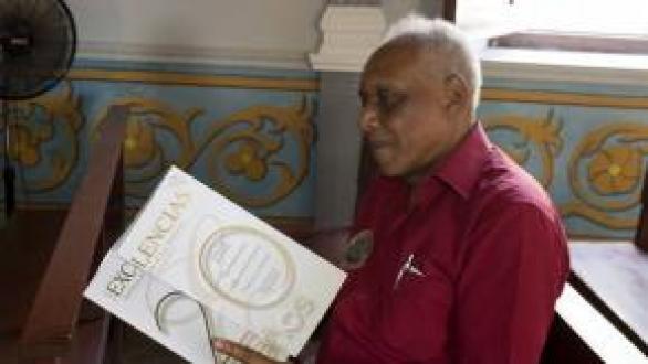 persona sentada con revista exccelencias en las manos