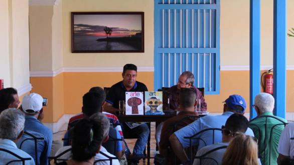 dos personas presentando revistas arte por excelencias