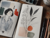 Cuaderno de ilustración abierto con bocetos, acuarelas y herramientas de dibujo sobre una mesa de artista, símbolo del auge de la ilustración contemporánea