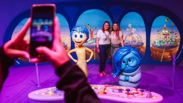 personas se toman fotos en la exposición Mundo Pixar