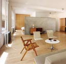 Overall view of the waiting room on the upper floor. The wall that divides the master bedroom and the bathroom from the living room is made of concrete. The furniture is made up of original pieces from the mid 20th century, hailing from a customer’s vast collection