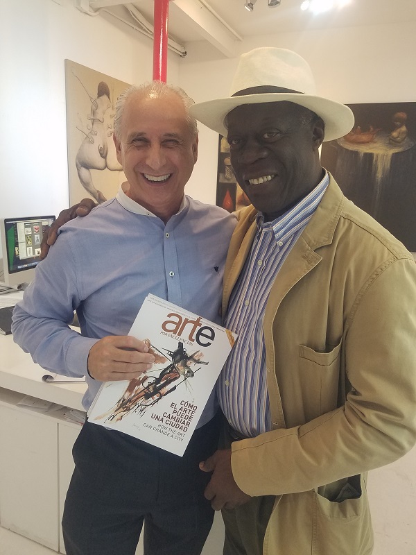 dos personas en galería de arte con revista Arte por Excelencias 