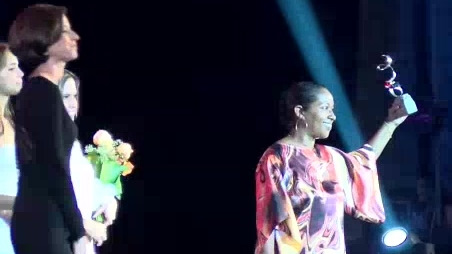 personas en escenario- recibe premio excelencias