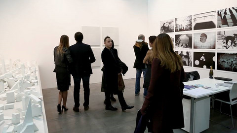 stand con obras de arte y personas interesadas 