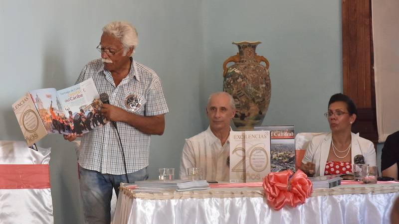 personas frente a una mesa- revistas- presentación revista excelencias